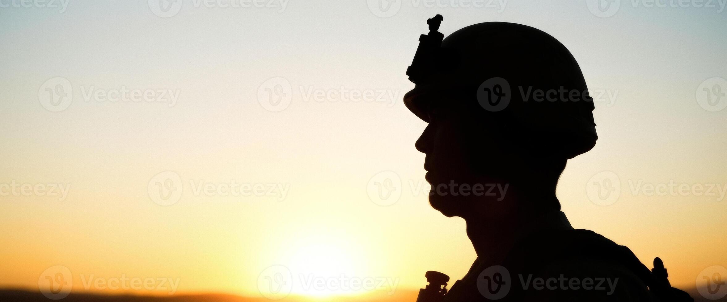 Silhouette of a man in a helmet against a sunset photo