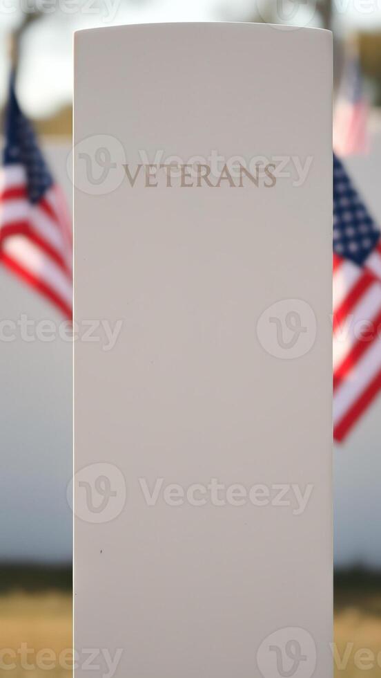 Veterans Memorial Monument with American Flags in Blurred Background photo
