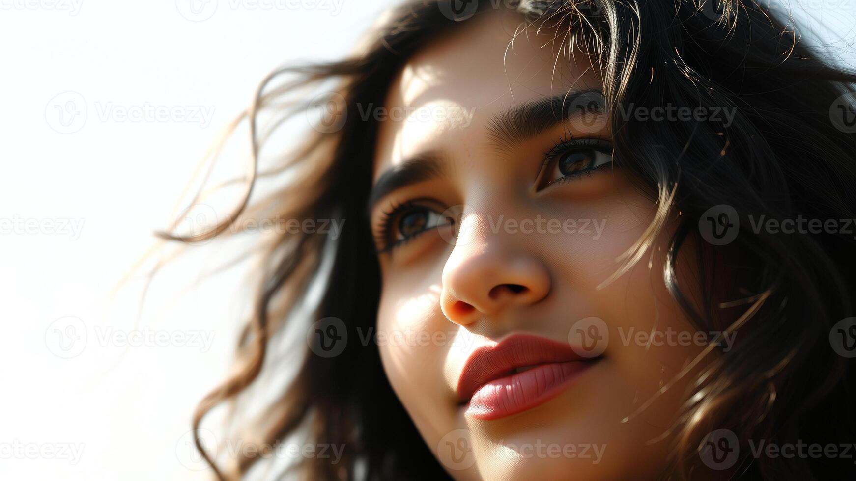 Close-up of a Young Woman with Wavy Hair Looking Up photo