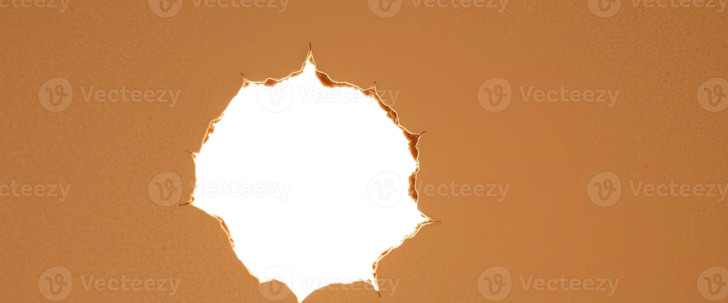 Torn brown paper with a hole in the center photo
