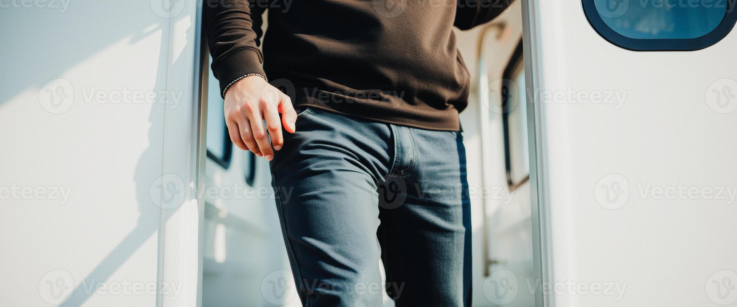 Man in Black Sweater and Blue Jeans Standing in Doorway photo