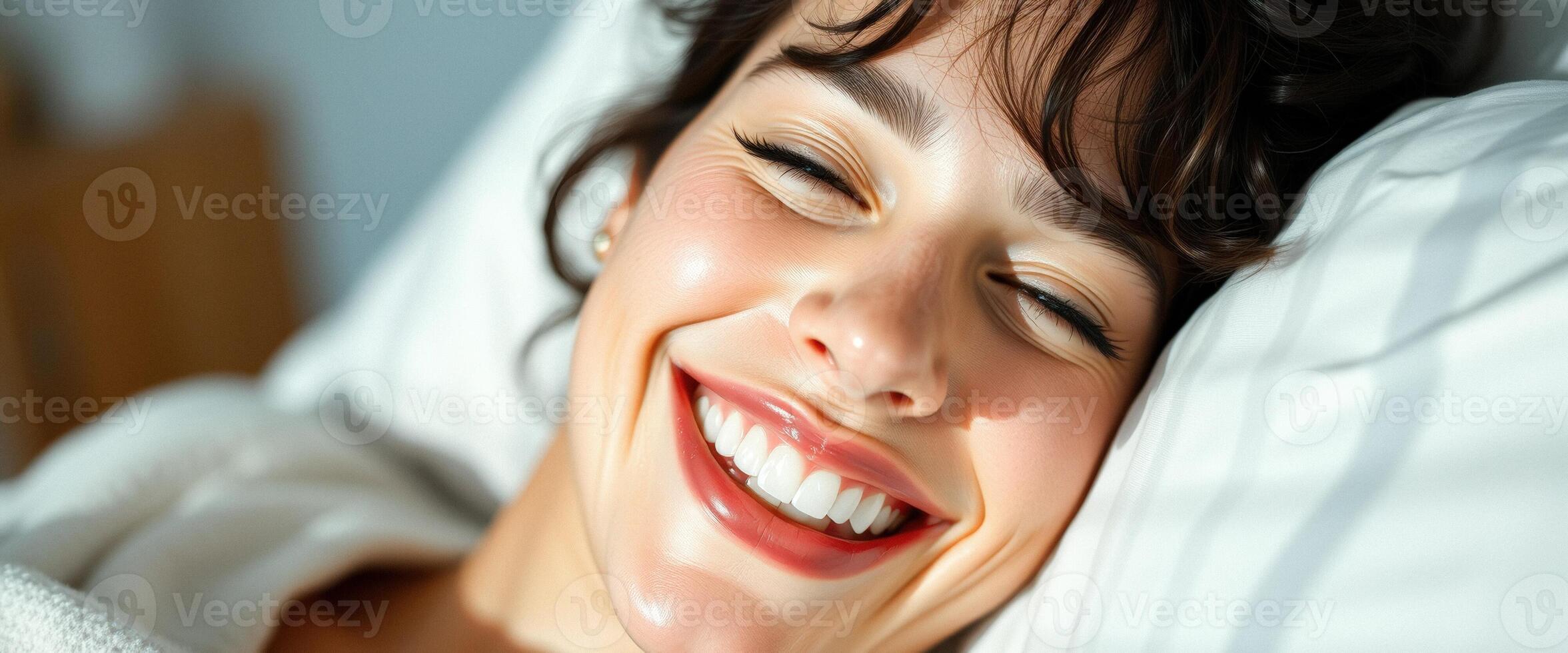 Close up portrait of a smiling woman lying in bed. photo