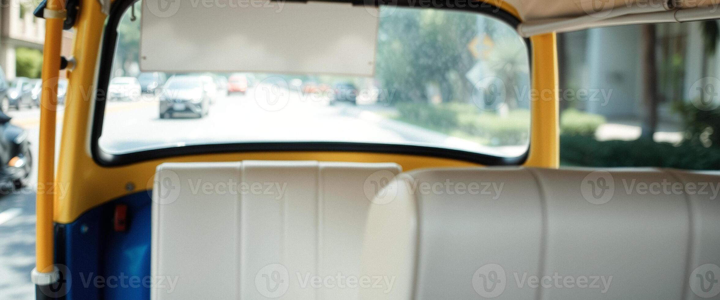 Backseat view of a yellow car driving through the city photo