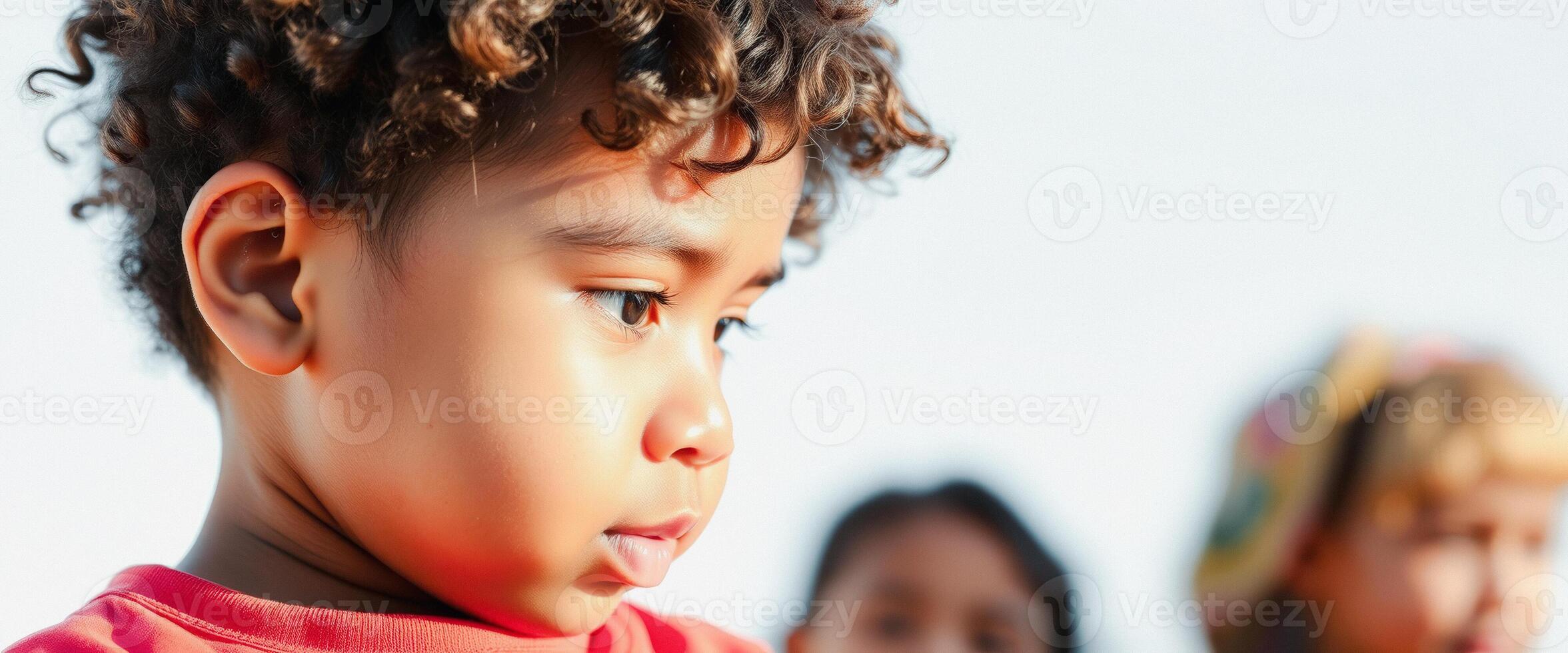 Close-up Portrait of a Young Boy with Curly Hair Looking Off to the Side photo