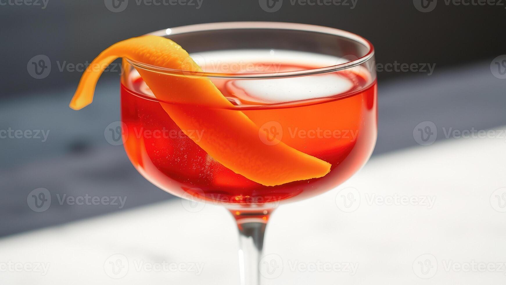 Close-up of a refreshing cocktail with an orange peel garnish photo