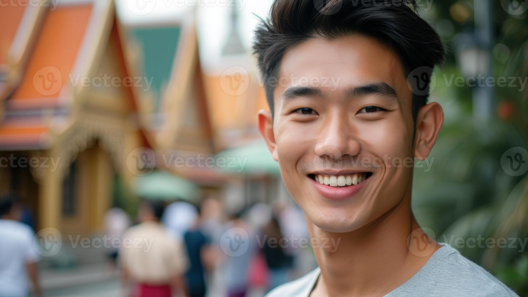 Smiling young man in front of a Thai temple photo
