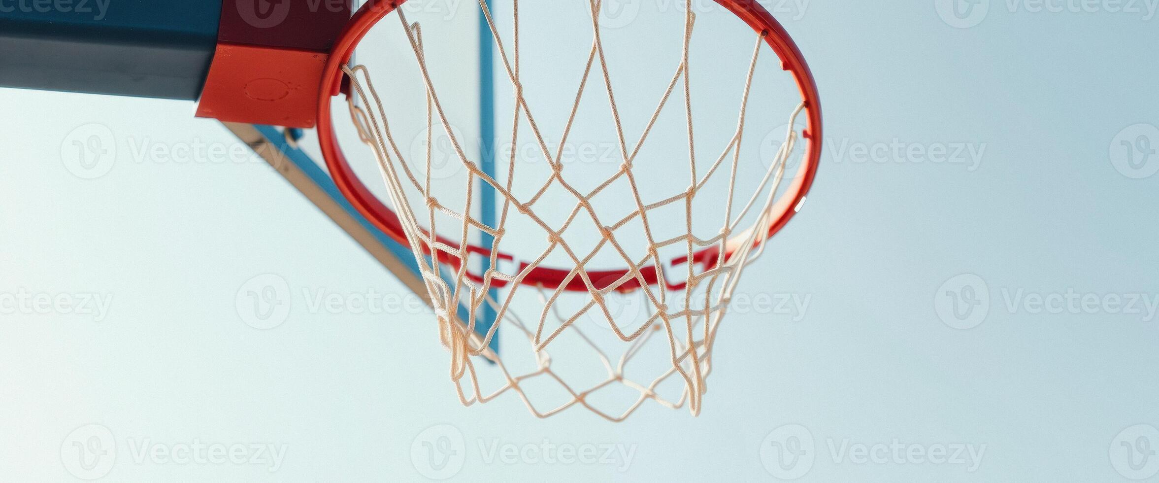 Close up of a basketball hoop net with a clear blue sky in the background photo