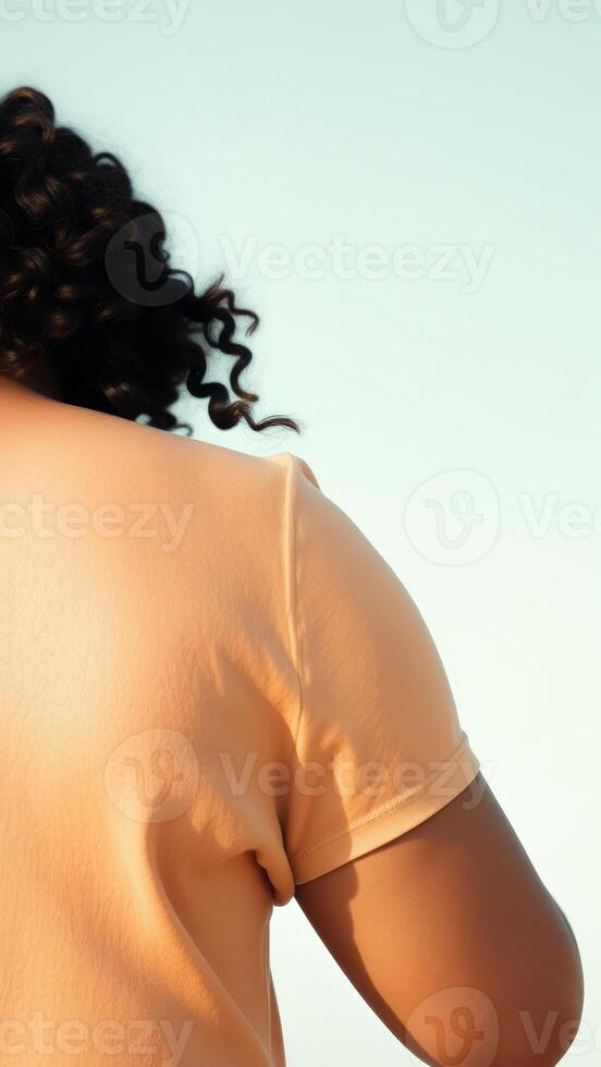 Close Up of a Woman's Shoulder in a Peach T-Shirt photo