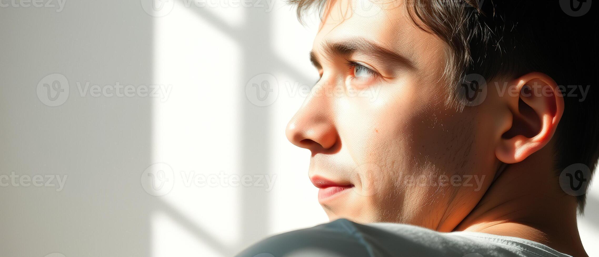 Young man looking away from the camera with a thoughtful expression photo