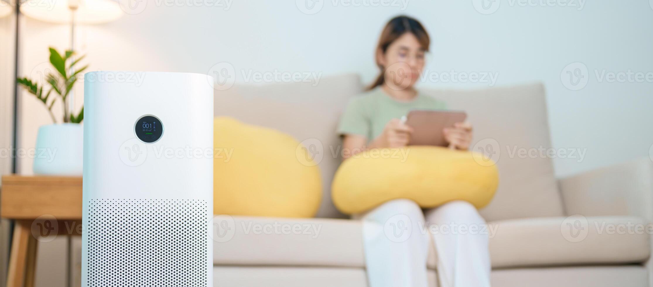 Air Purifier with woman relax and use tablet on sofa. Purification system for filter and cleaning dust PM2.5 HEPA and virus in home. Allergy, Pure air, health, Wellness lifestyle and Air Pollution photo