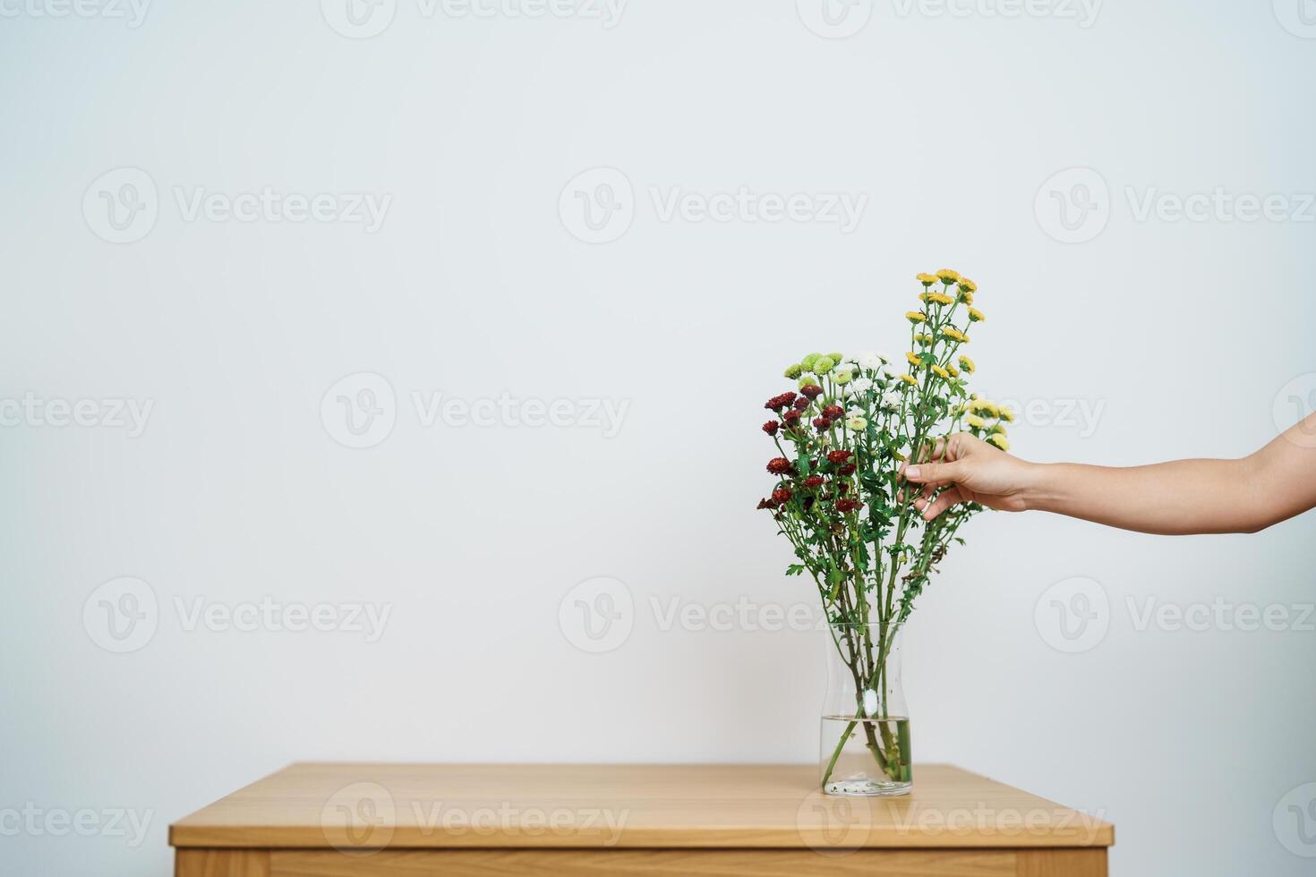 Woman hand arrange Colorful flowers bouquet in mason jar on table background. Happy day with fresh flower photo