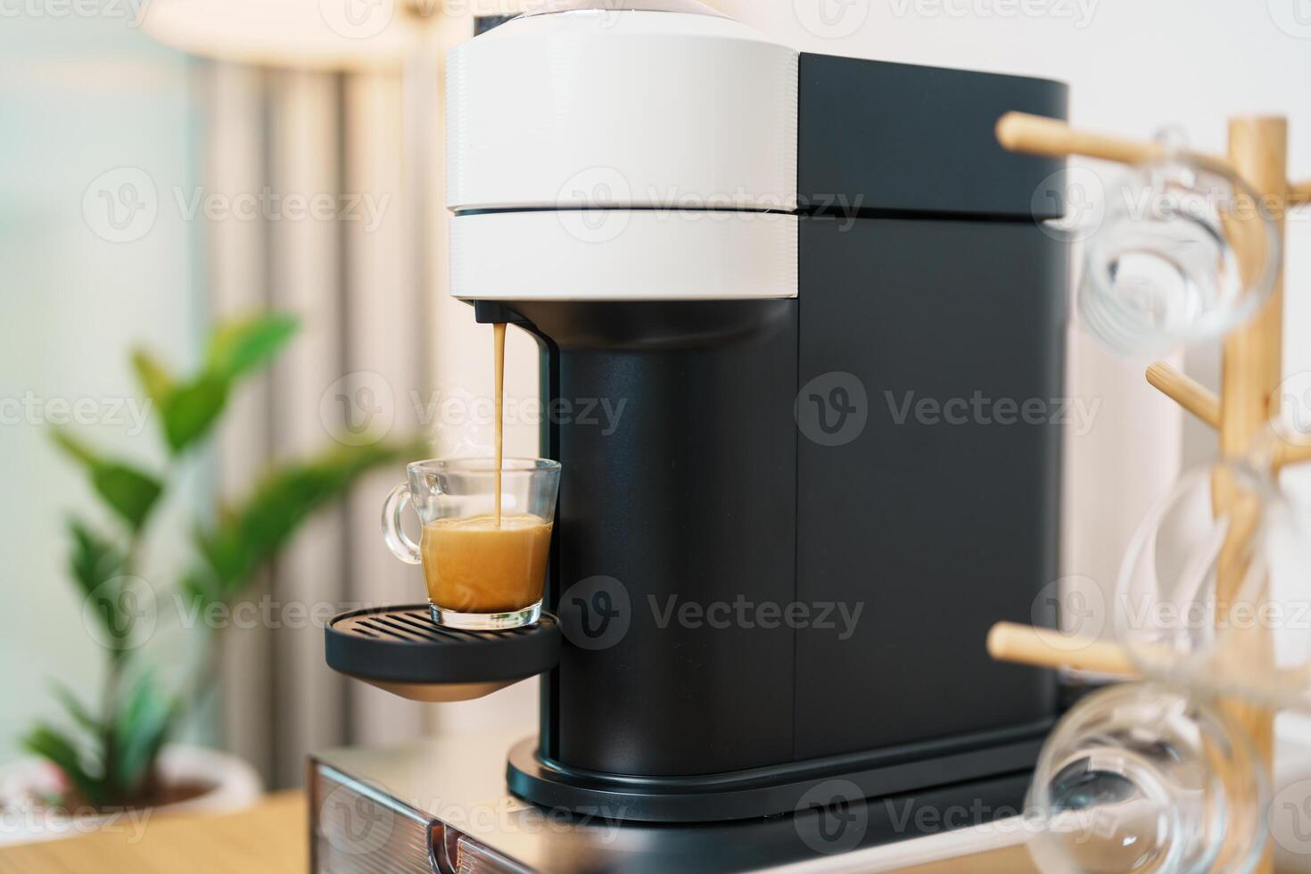 Espresso cup with steam and froth during Coffee making Coffee by Coffee Maker Machine on wood table bar. Cafe shop, Daily beverage drink at Home, Apartment and Office concept photo