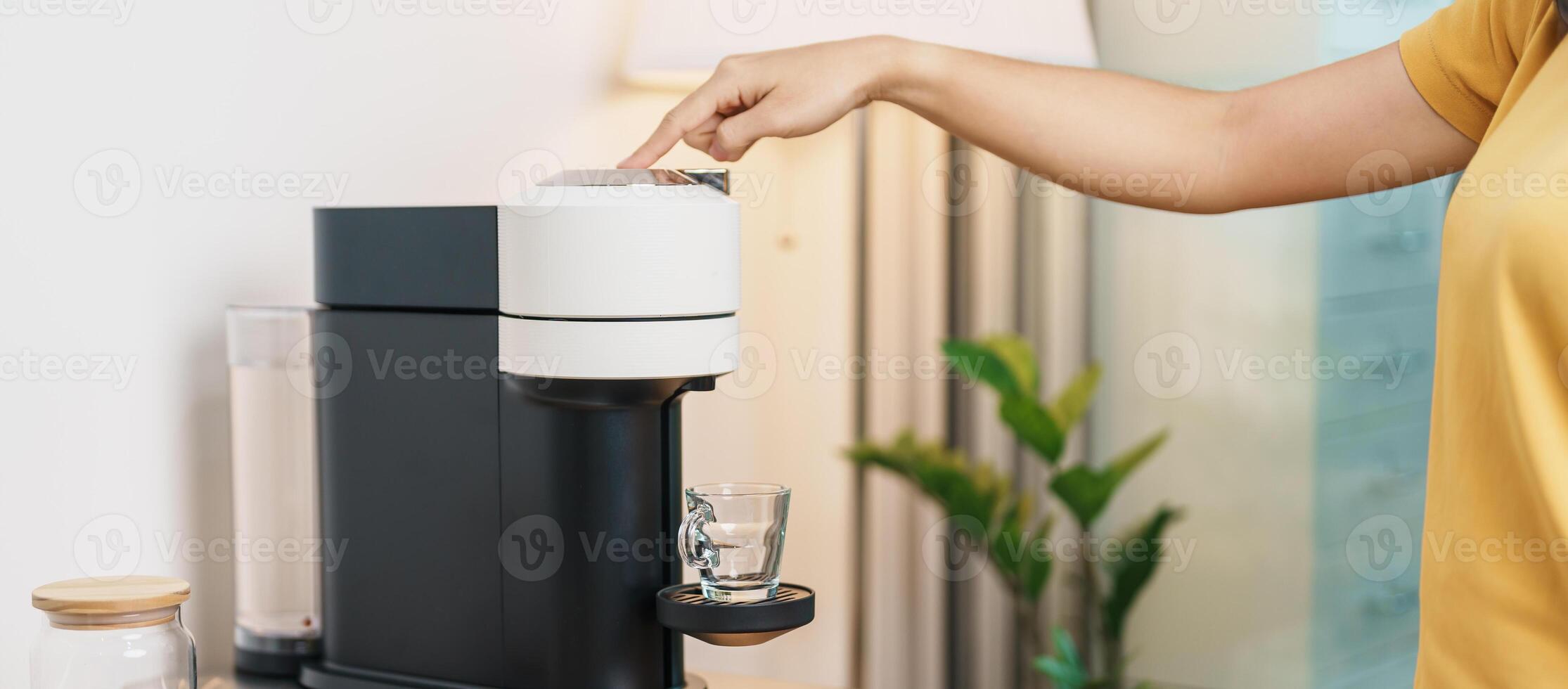 hand making Espresso Coffee by Coffee Maker Machine on wood table bar. Daily beverage drink at Home, Apartment and Office concept photo