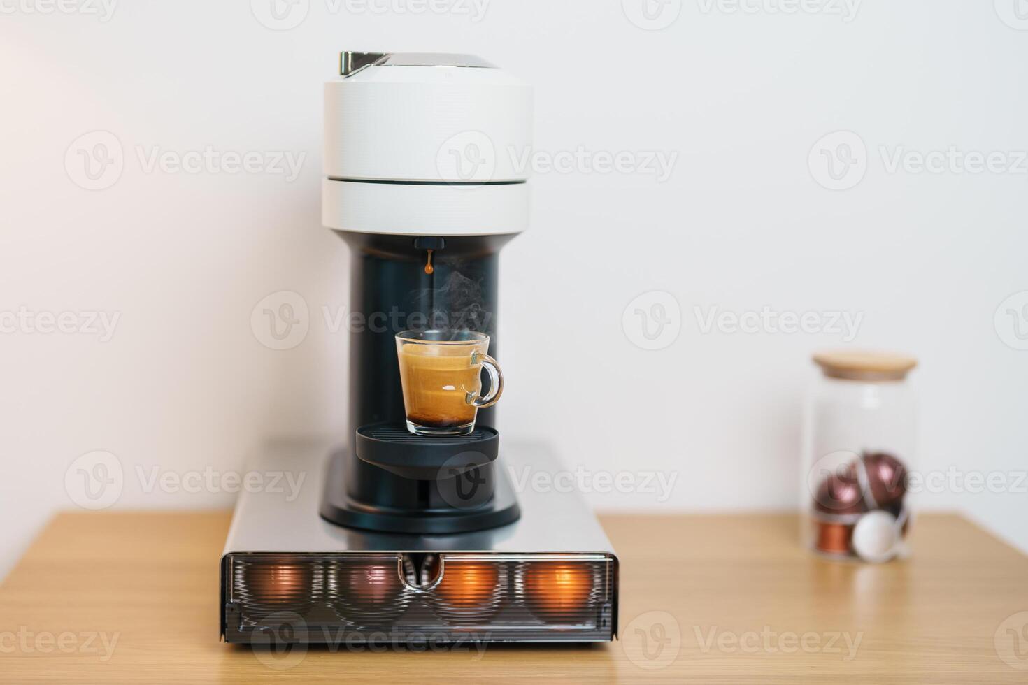 Espresso Coffee Maker Machine with Capsule of roasted coffee bean on wood table bar. Daily beverage drink at Home, Apartment and Office concept photo