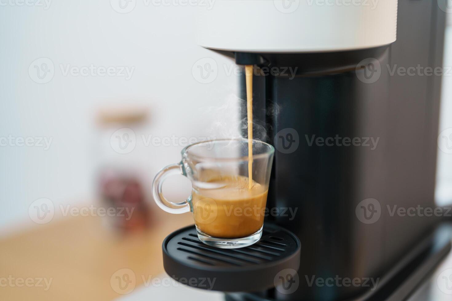Espresso cup with steam and froth during Coffee making Coffee by Coffee Maker Machine on wood table bar. Cafe shop, Daily beverage drink at Home, Apartment and Office concept photo