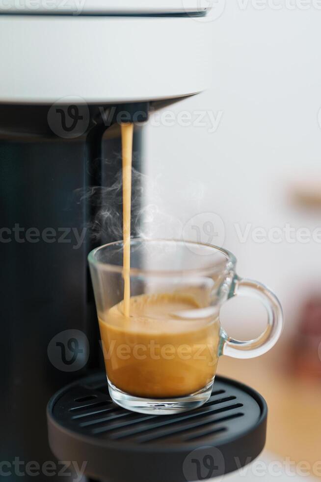Espresso cup with steam and froth during Coffee making Coffee by Coffee Maker Machine on wood table bar. Cafe shop, Daily beverage drink at Home, Apartment and Office concept photo
