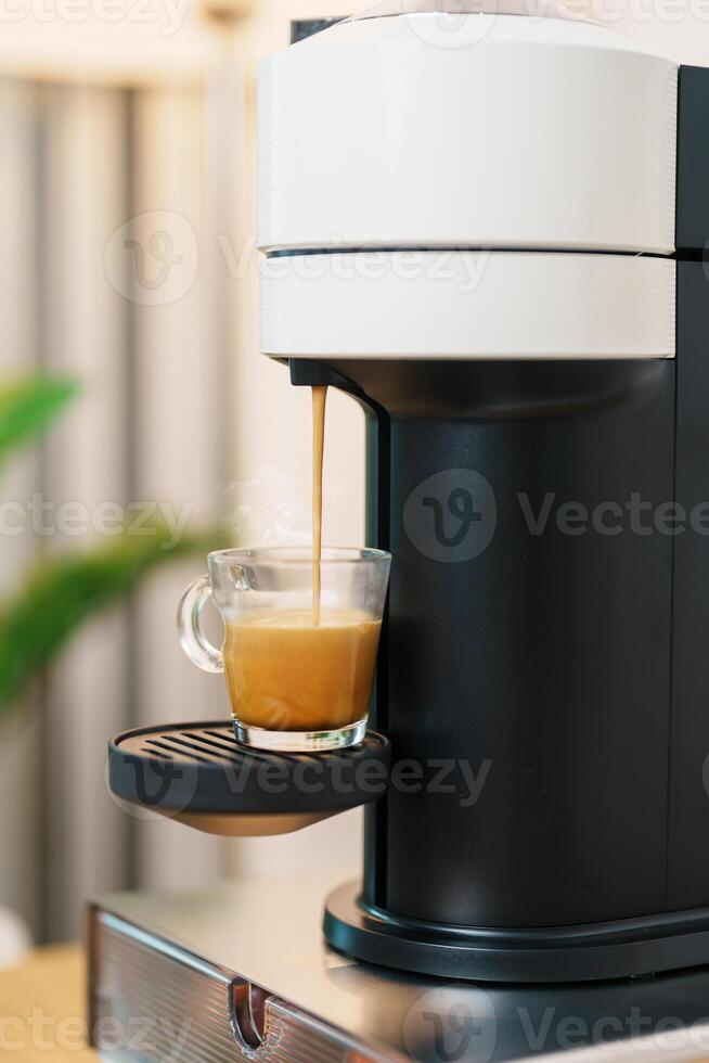 Espresso cup with steam and froth during Coffee making Coffee by Coffee Maker Machine on wood table bar. Cafe shop, Daily beverage drink at Home, Apartment and Office concept photo