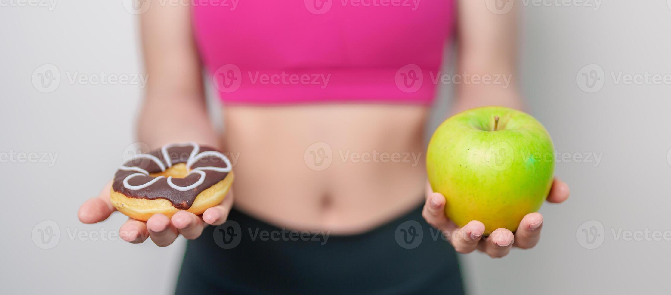 woman hand hold green Apple and donut, female fitness choose between fruit is Healthy and sweet is Unhealthy junk food. Dieting control, Weight loss, Obesity, eating lifestyle and nutrition concept photo