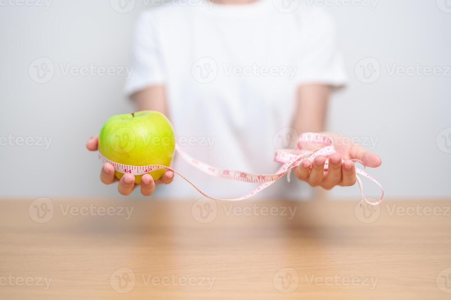 woman hand hold green Apple with tape measure, happy female choose fruit is Healthy food. Dieting control, Weight loss, Obesity, eating lifestyle and nutrition concepts photo