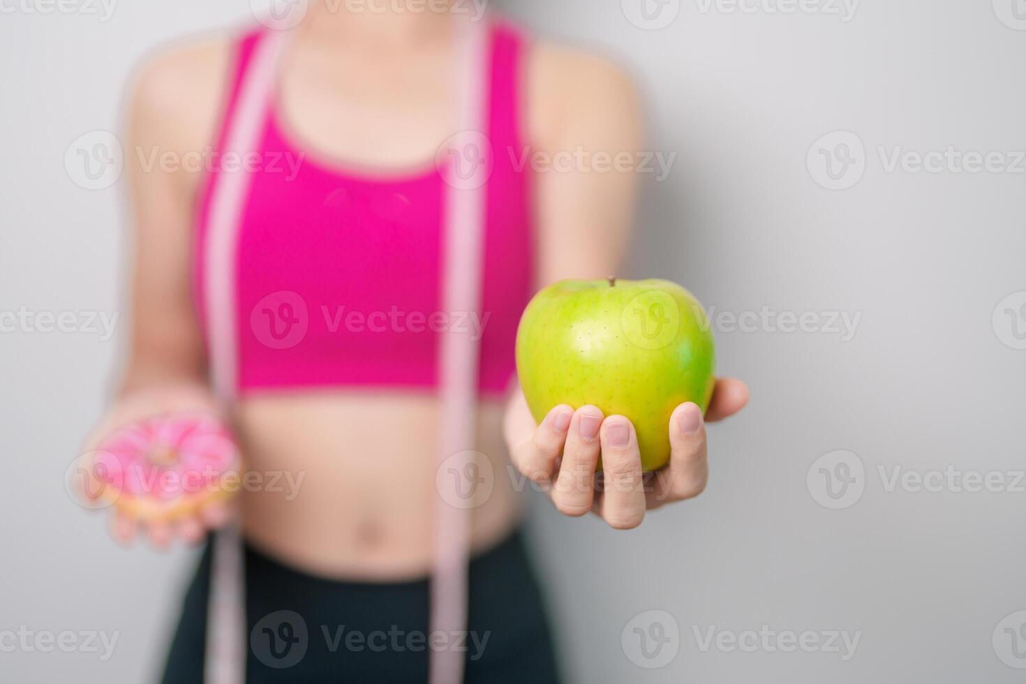 woman hand hold green Apple and donut, female fitness choose between fruit is Healthy and sweet is Unhealthy junk food. Dieting control, Weight loss, Obesity, eating lifestyle and nutrition concept photo
