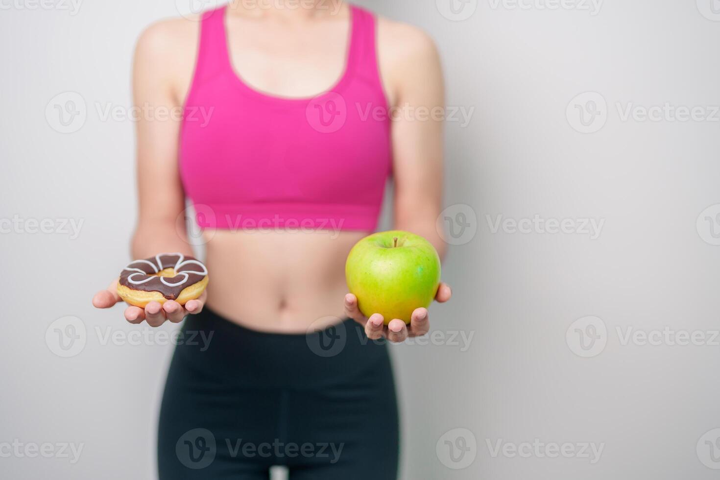 woman hand hold green Apple and donut, female fitness choose between fruit is Healthy and sweet is Unhealthy junk food. Dieting control, Weight loss, Obesity, eating lifestyle and nutrition concept photo