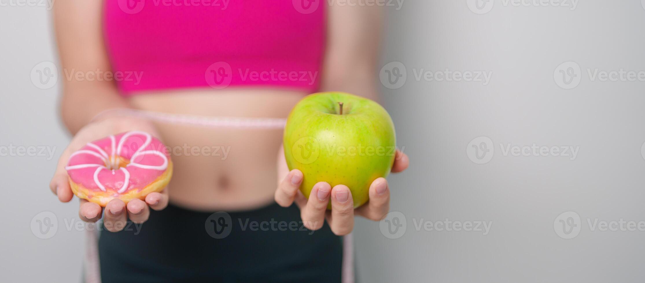 woman hand hold green Apple and donut, female fitness choose between fruit is Healthy and sweet is Unhealthy junk food. Dieting control, Weight loss, Obesity, eating lifestyle and nutrition concept photo