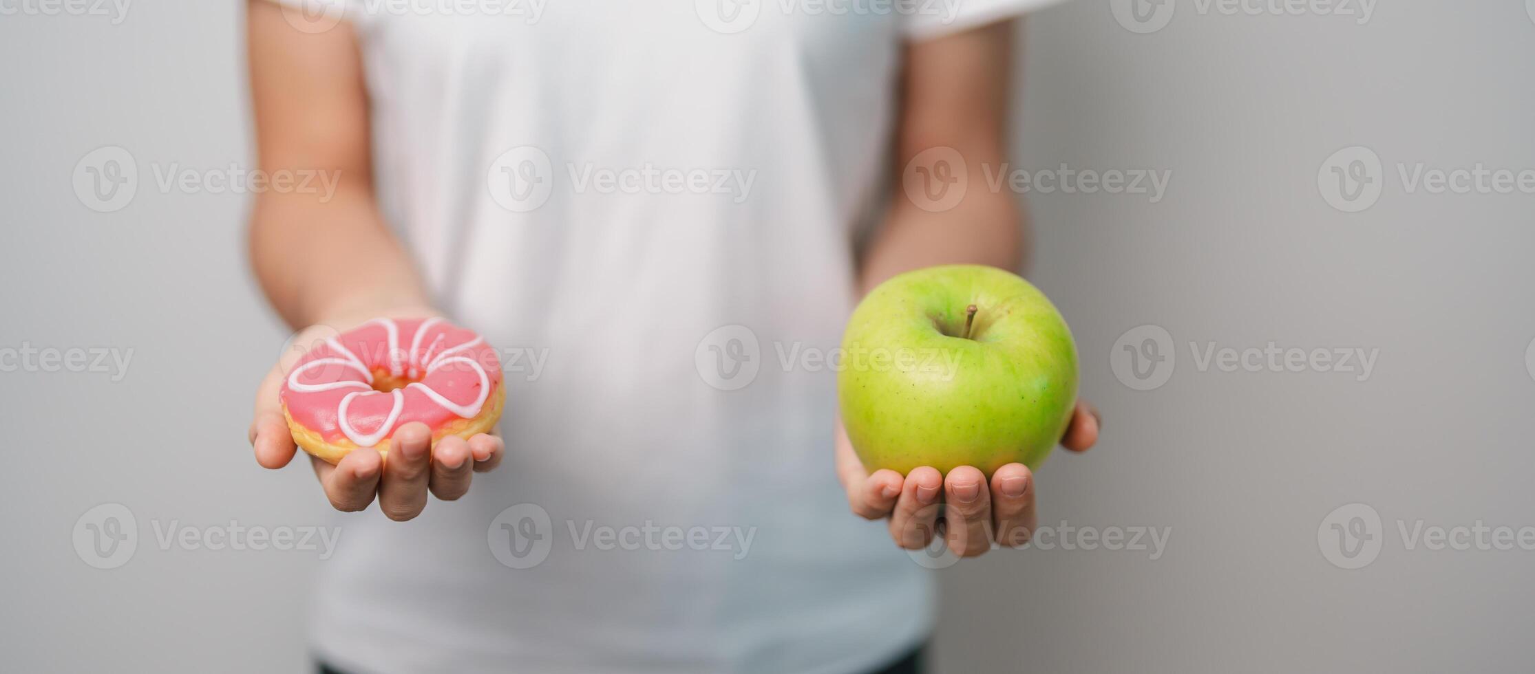 woman hand hold green Apple and donut, female fitness choose between fruit is Healthy and sweet is Unhealthy junk food. Dieting control, Weight loss, Obesity, eating lifestyle and nutrition concept photo