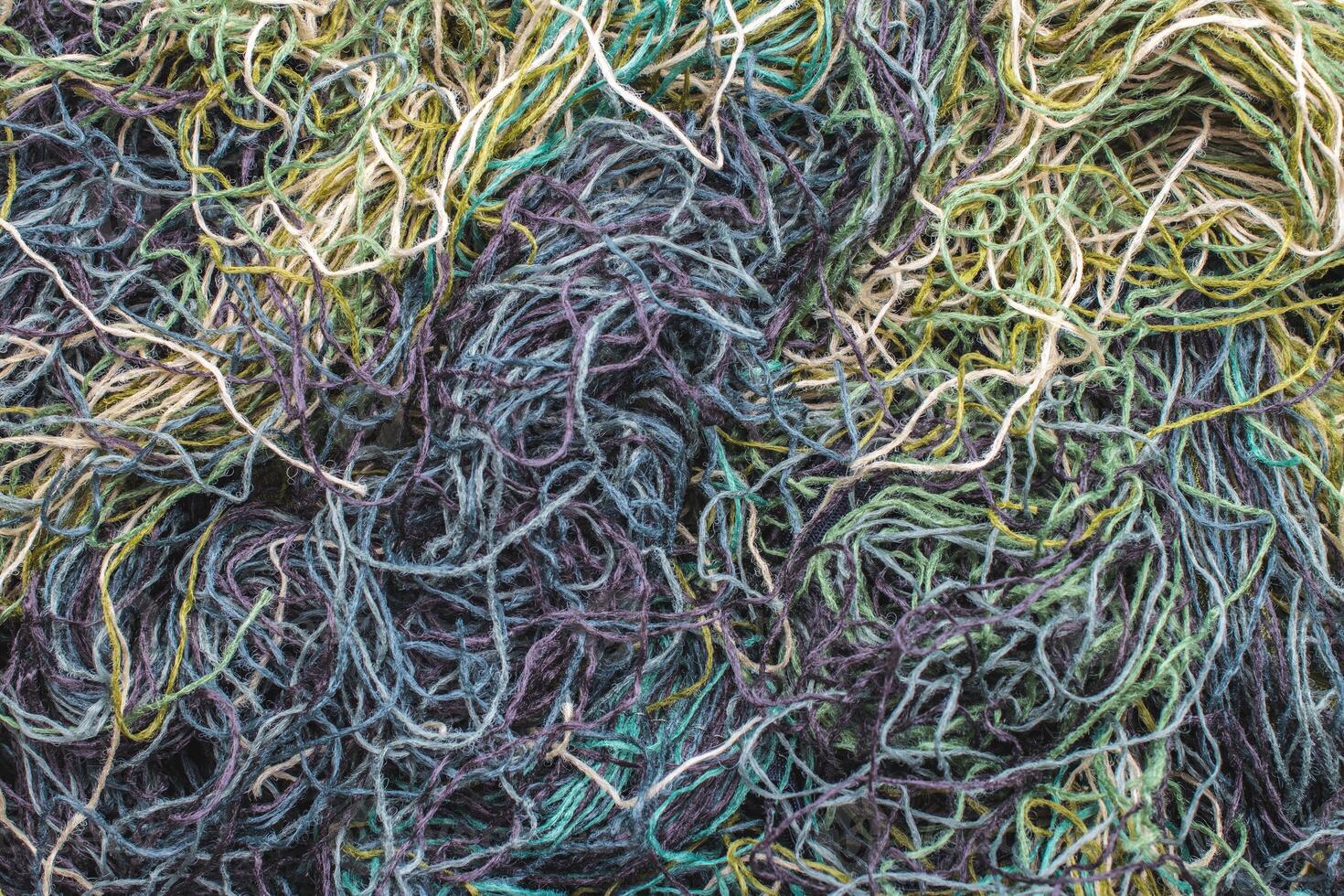 background of colored threads chaotically intertwined. green yellow and brown threads matted in a colorful background photo