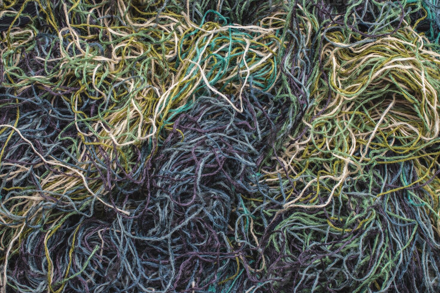 background of colored threads chaotically intertwined. green yellow and brown threads matted in a colorful background photo
