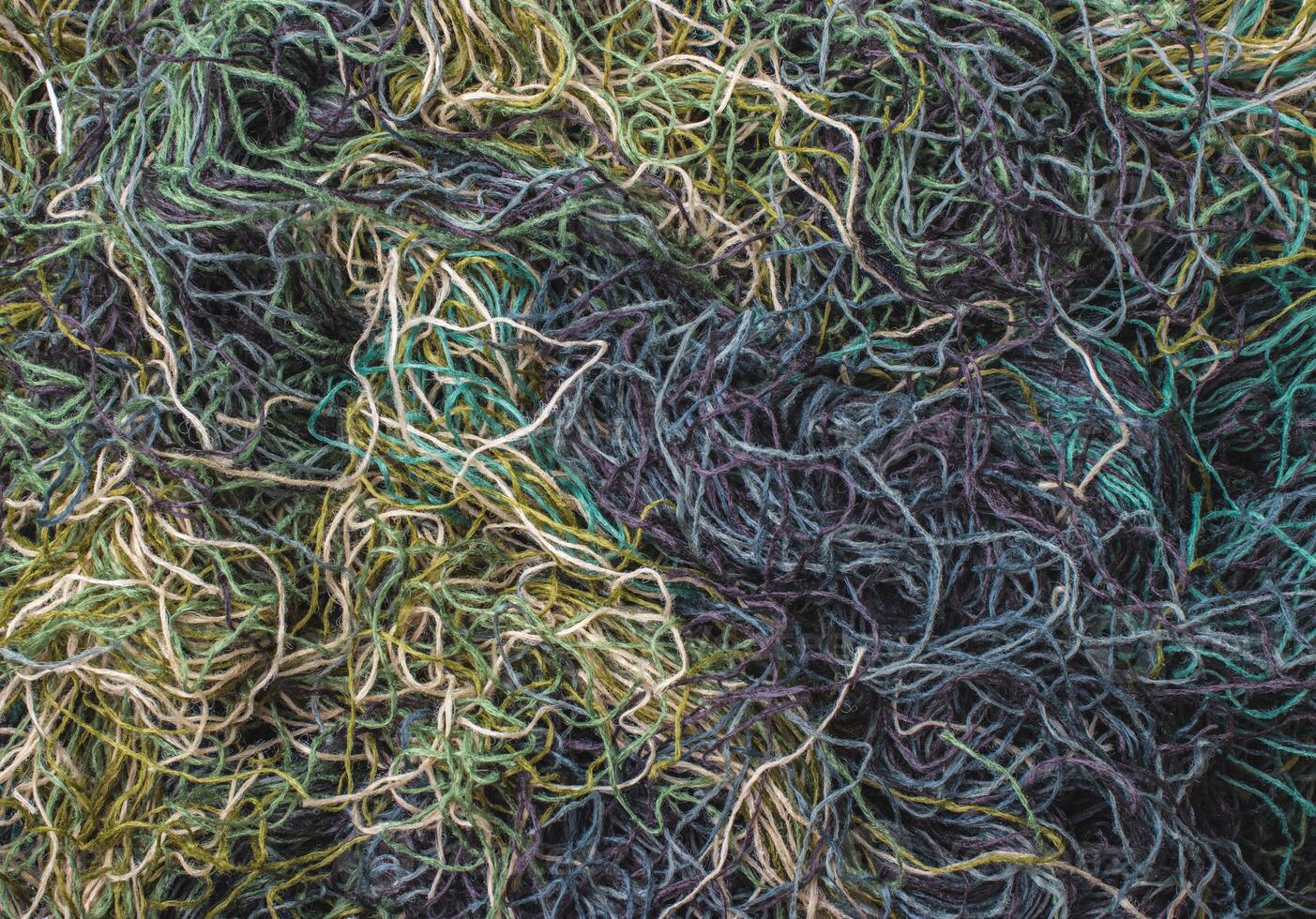 background of colored threads chaotically intertwined. green yellow and brown threads matted in a colorful background photo