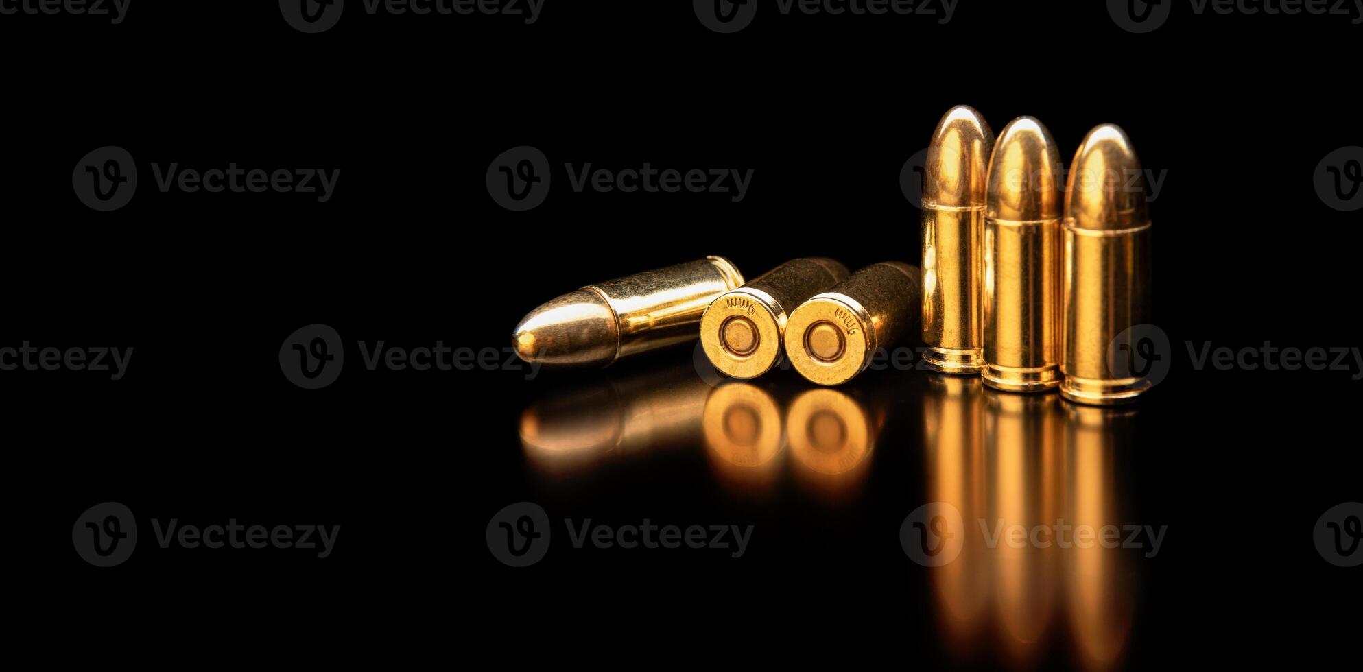 Pistol cartridges 9 mm on a smooth glossy surface with reflections. Ammunition for pistols and PCC carbines on a dark back. photo