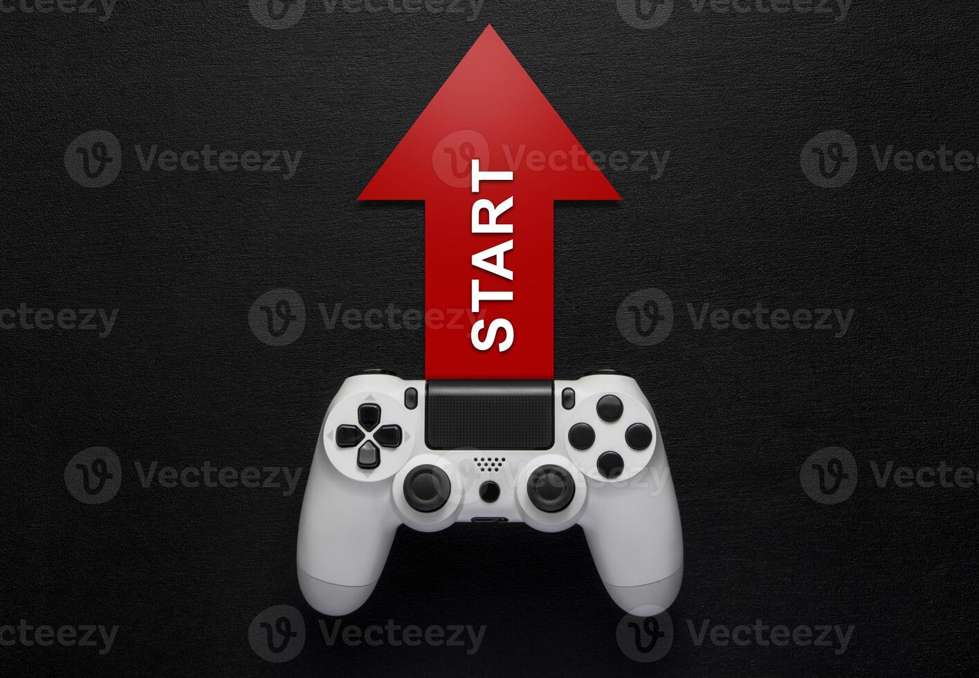 white modewrn gamepad and red arrow with strart on a dark background photo