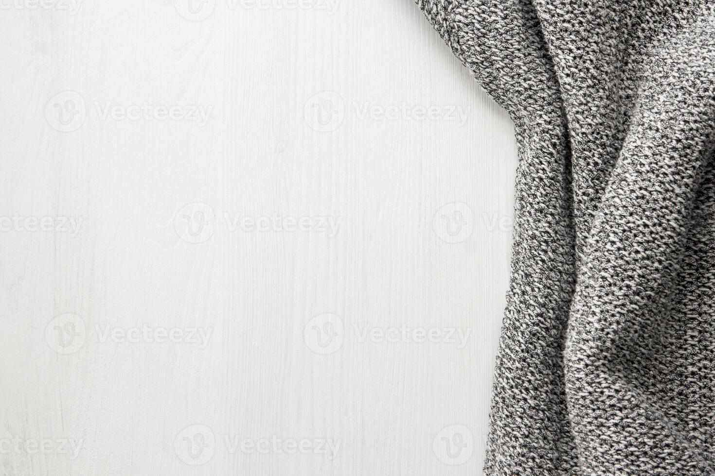 Gray knitted cloth on a white wooden background. photo