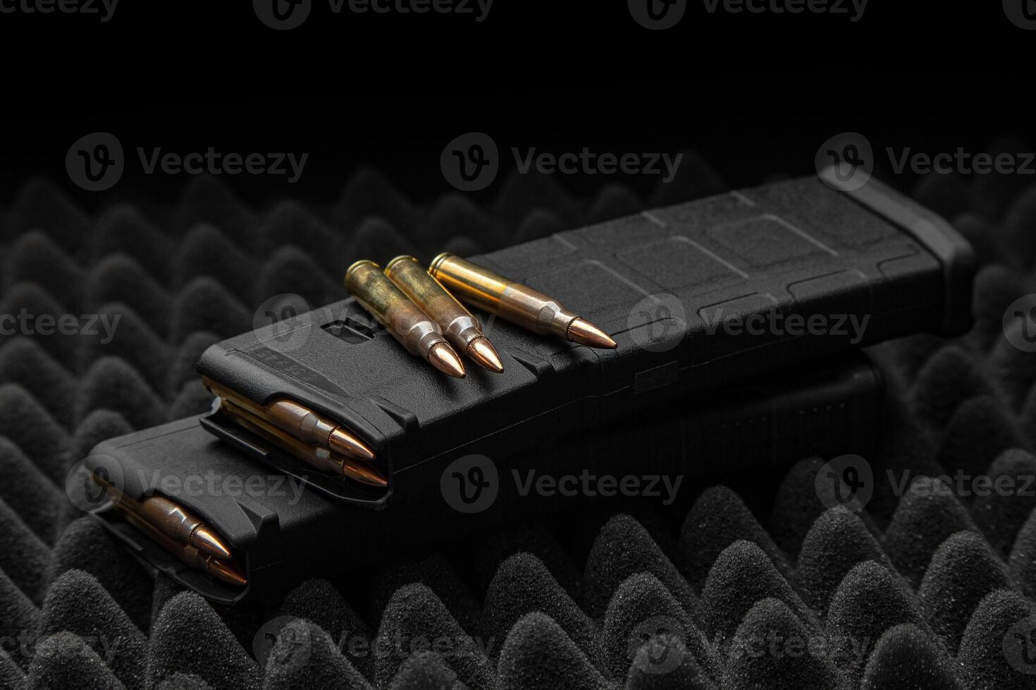 Cartridges and clips for a rifle or carbine. Ammunition for weapons. Ammunition for weapon lies on a foam dark back. photo