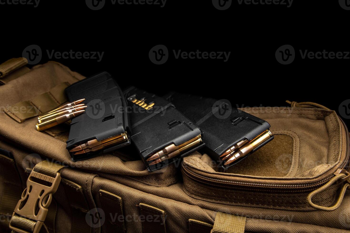 Cartridges and clips for a rifle or carbine. Ammunition for weapons. Ammunition for weapons lies on a military backpack. Dark back. photo