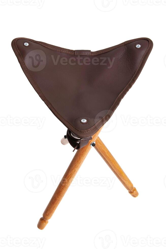 Folding wooden hunting stool tripod isolate on white background. Three-legged camping chair. photo
