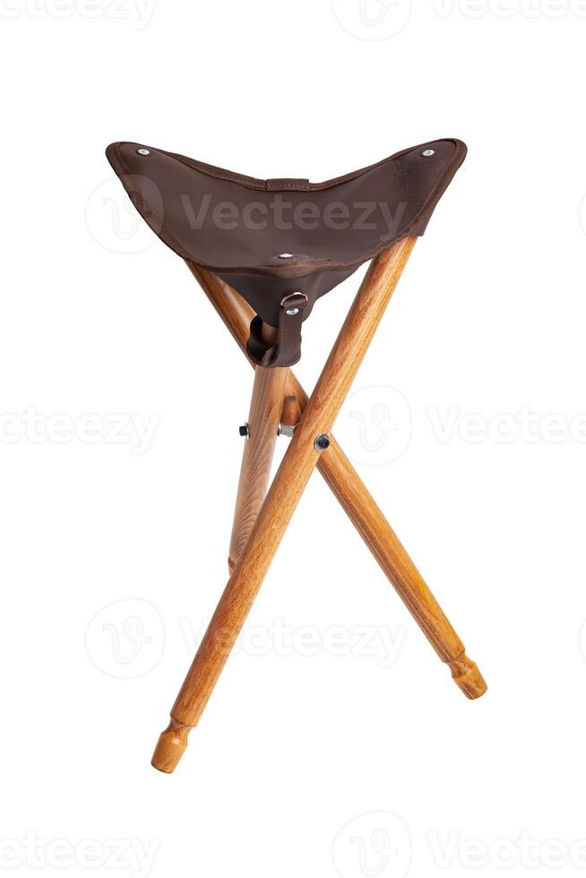 Folding wooden hunting stool tripod isolate on white background. Three-legged camping chair. photo