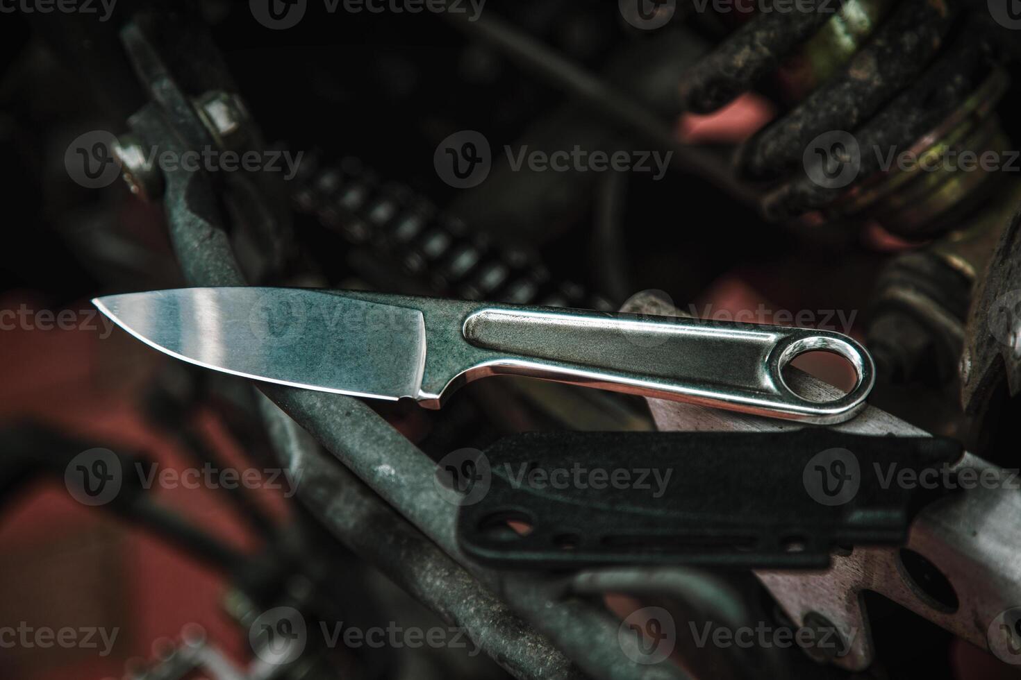 A knife with a metal handle made from a wrench. Tool weapon. Motorcycle engine on the back. photo