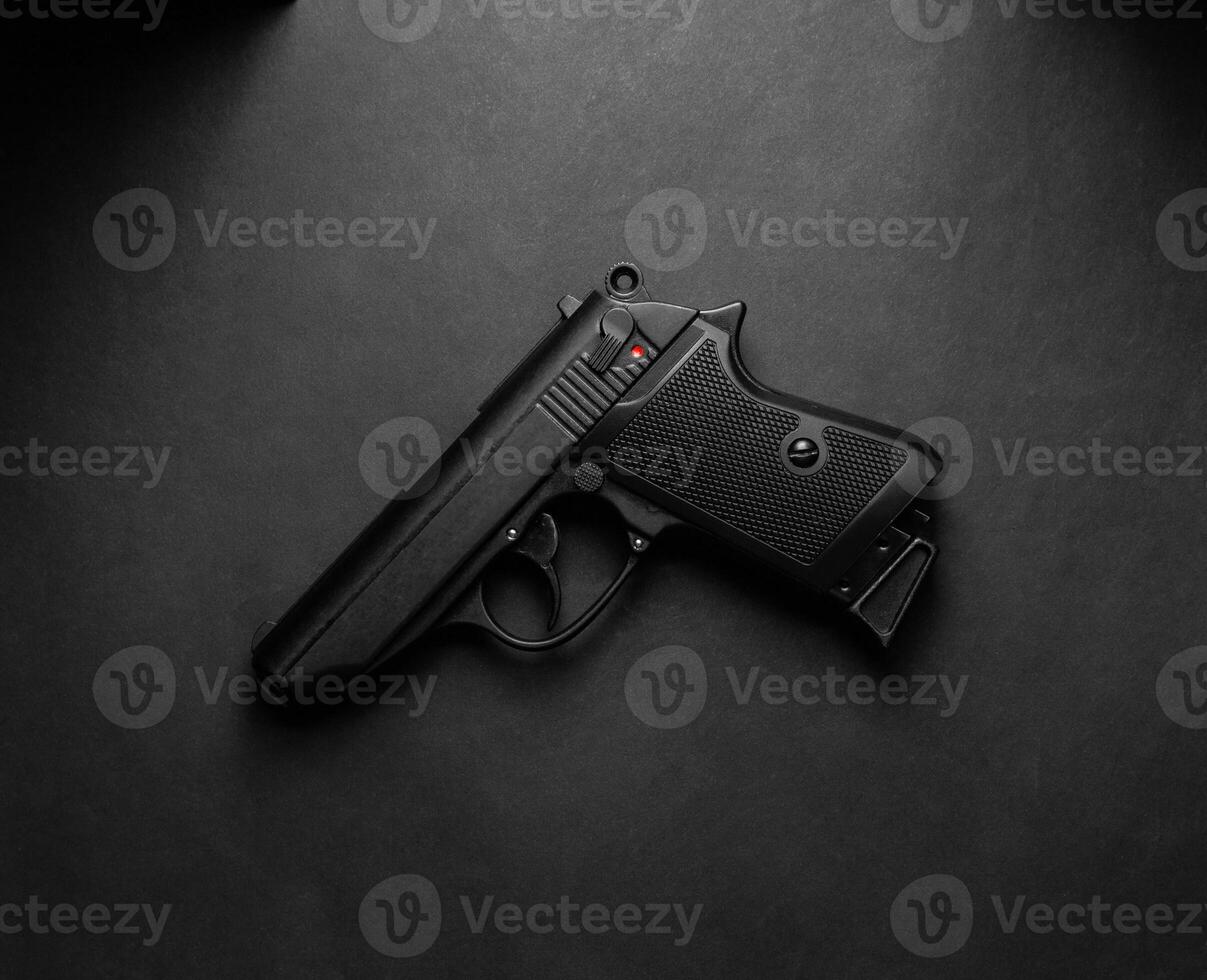 Modern semi-automatic pistol. Armament for the army and police. Short-barreled weapon. Dark back photo