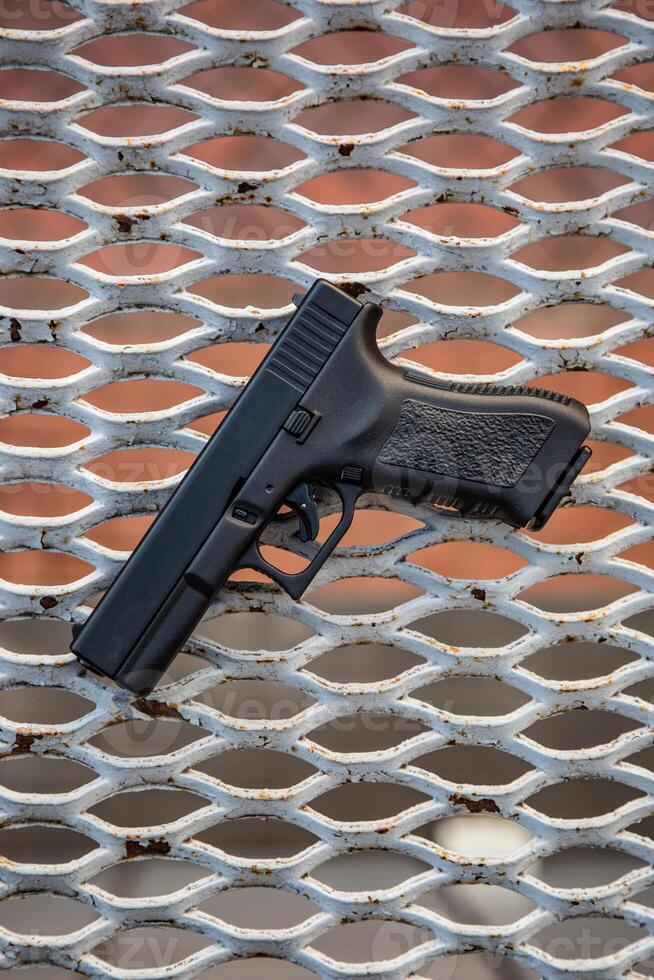 Modern semi-automatic pistol. Armament for the army and police. Short-barreled weapon. Metal lattice back photo