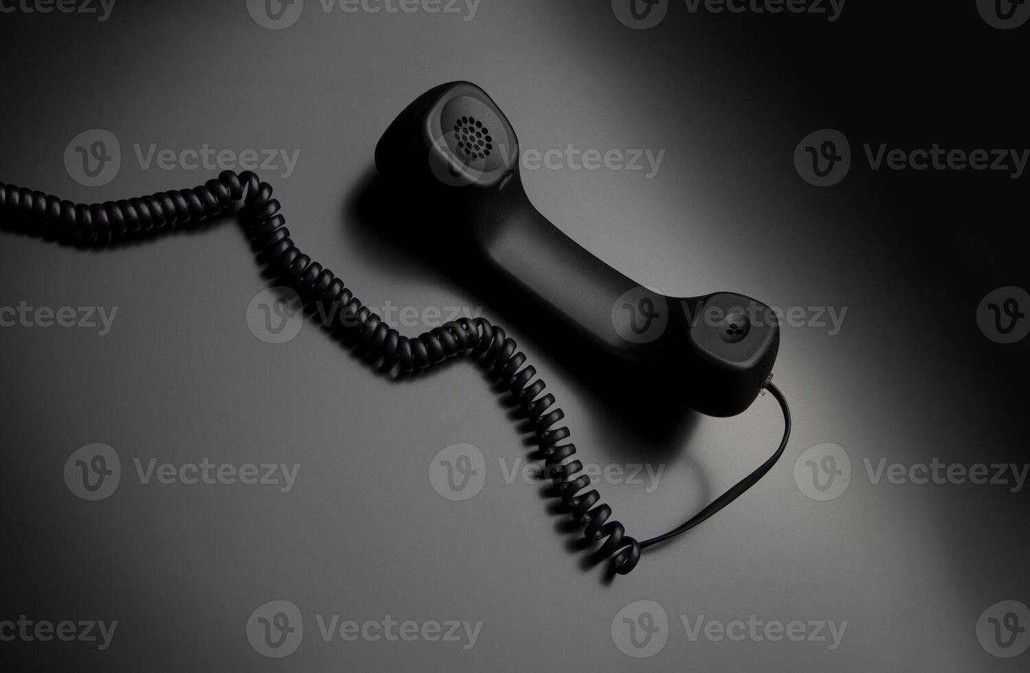 modern telephone receiver on dark back. concept technical support by phone. waiting for an answer. no answer. photo