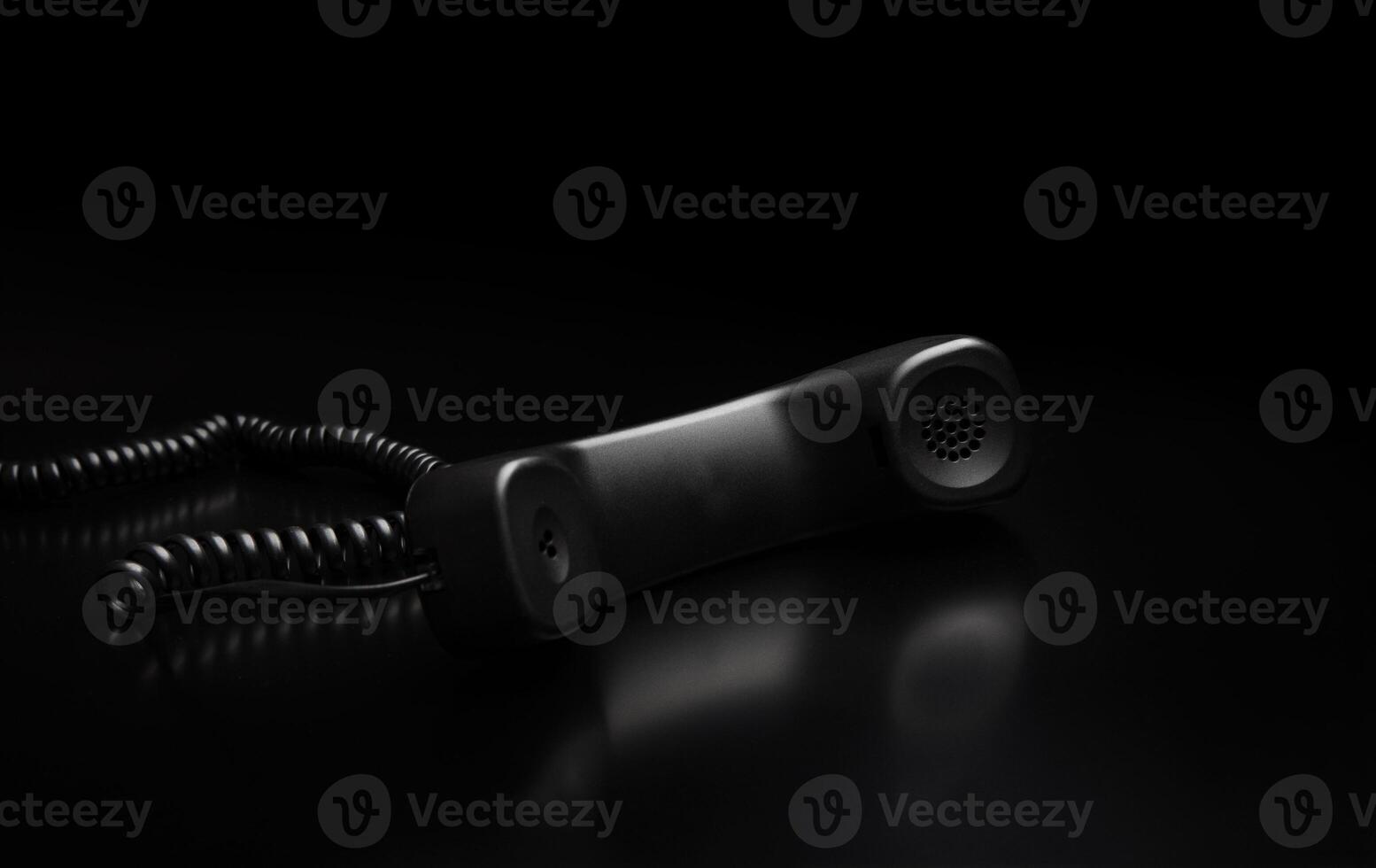 modern telephone receiver on dark back. concept technical support by phone. waiting for an answer. no answer. photo