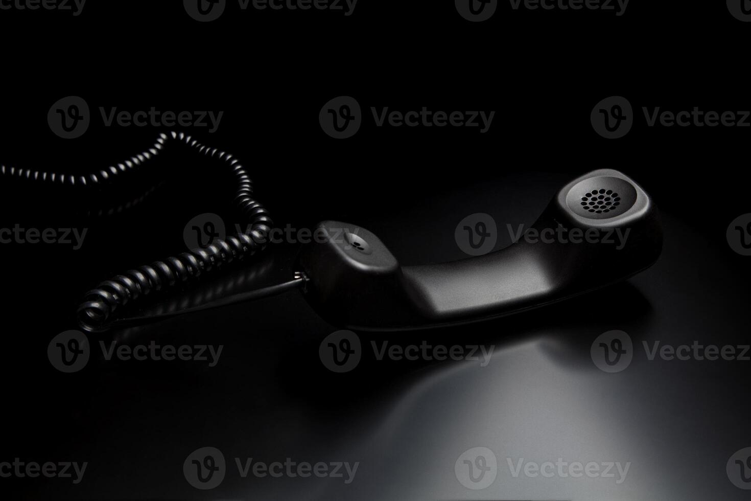 modern telephone receiver on dark back. concept technical support by phone. waiting for an answer. no answer. photo