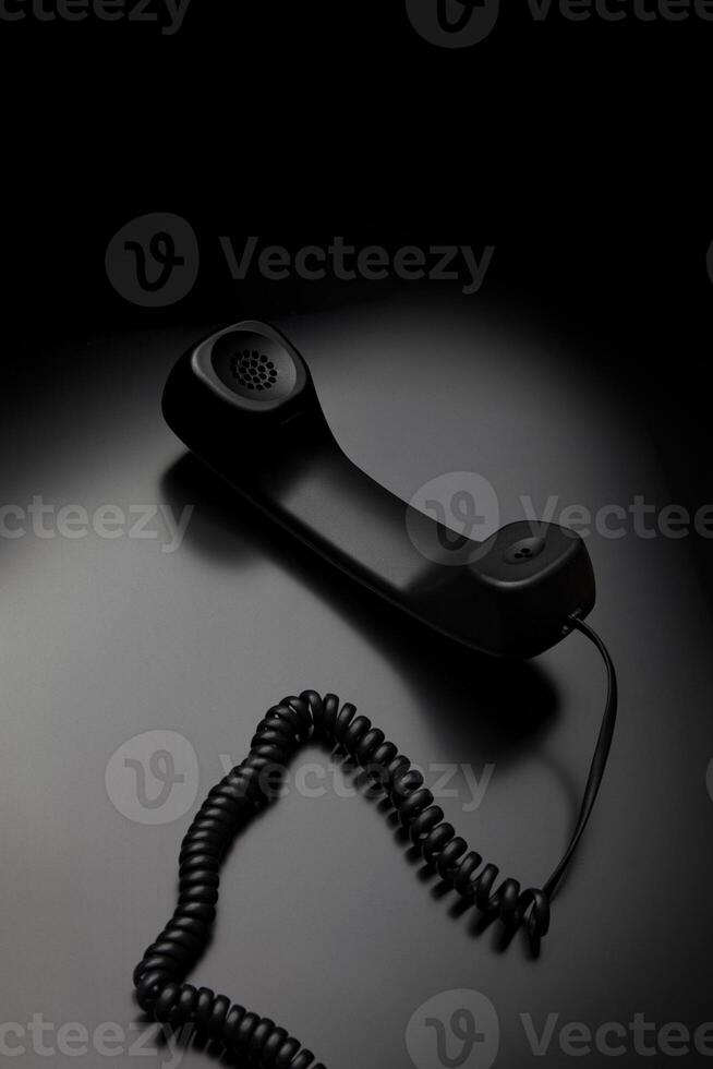 modern telephone receiver on dark back. concept technical support by phone. waiting for an answer. no answer. photo