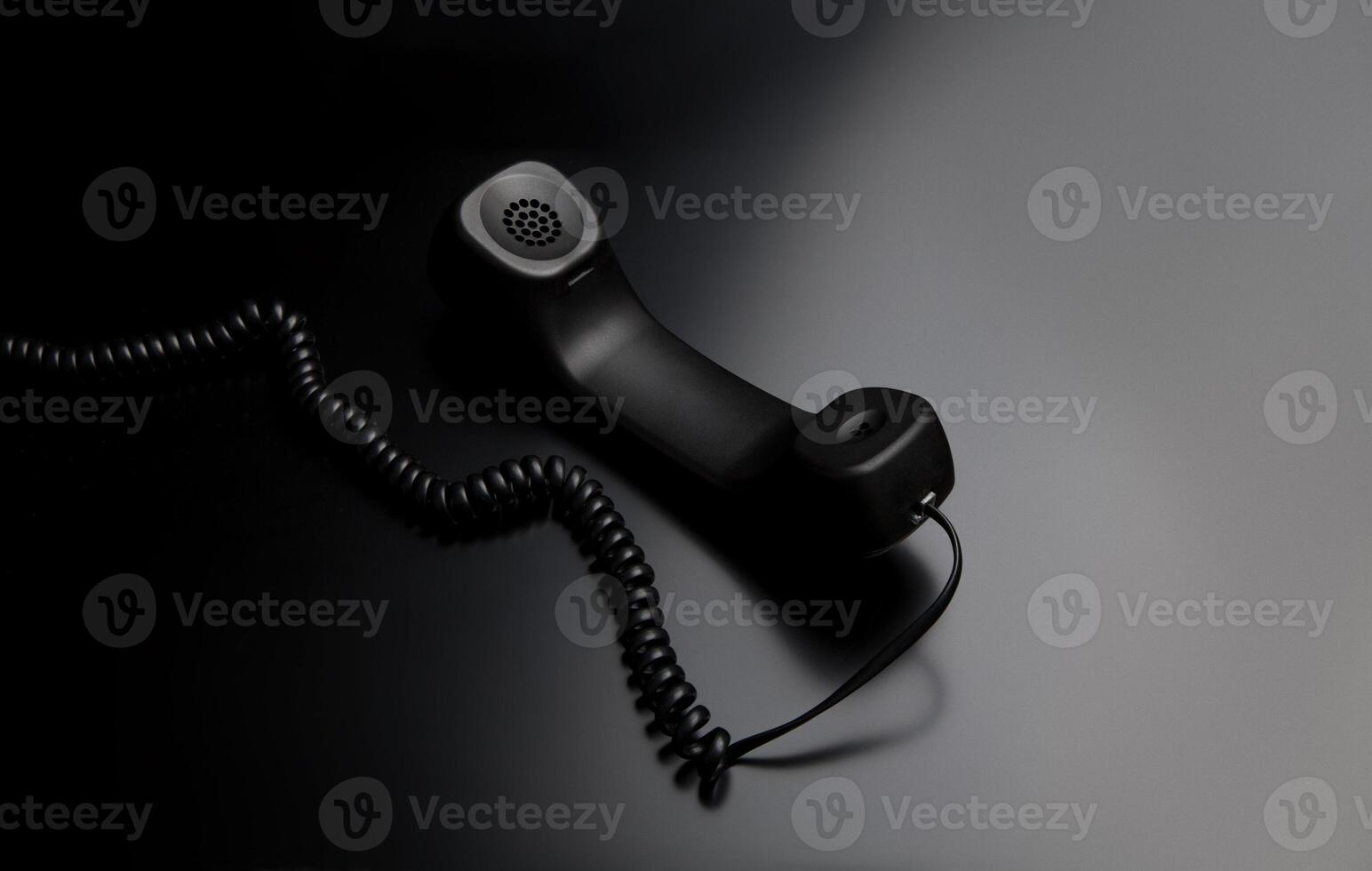 modern telephone receiver on dark back. concept technical support by phone. waiting for an answer. no answer. photo