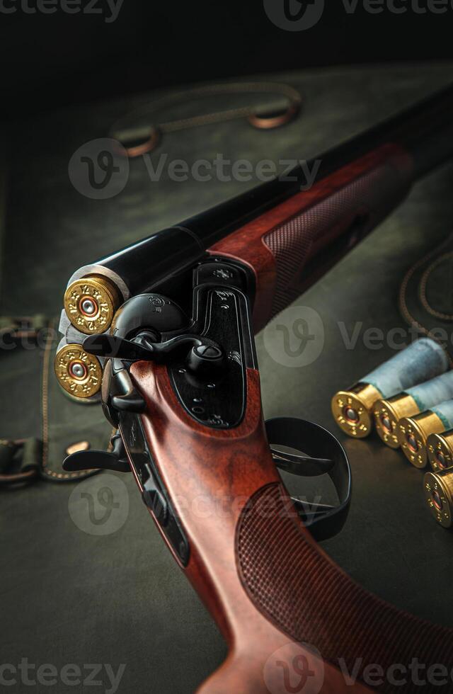 Classic trigger double-barreled hunting rifle on a green background. Smooth-bore hunting rifle open for reloading. Concept postcards for hunters. photo
