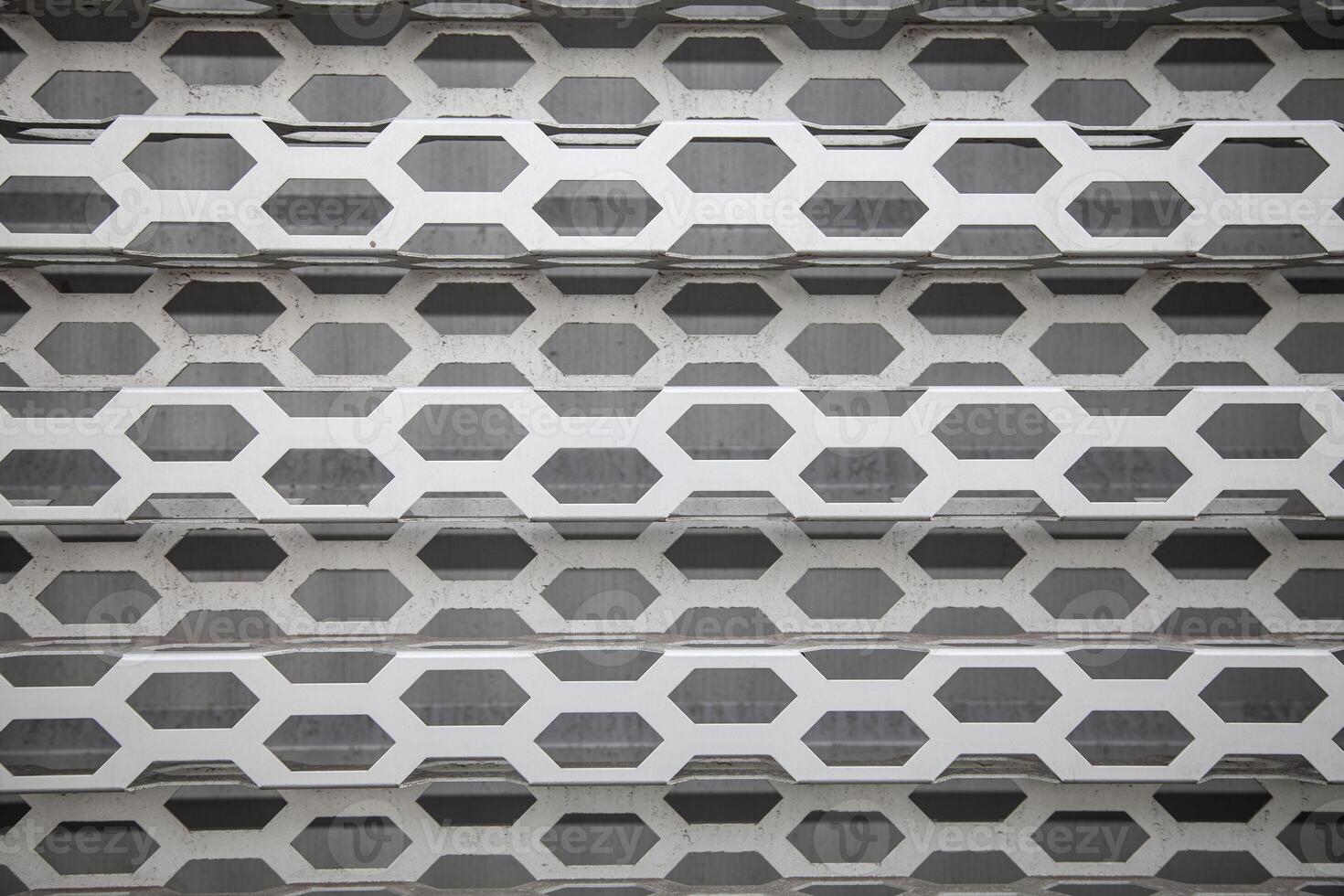 Background of wavy metallic grid with holes. Metal mesh as background. Perforated metal back. photo