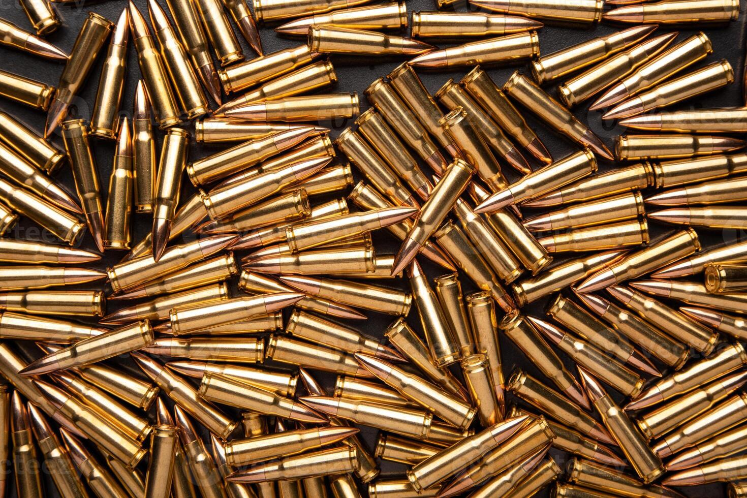 A pile of ammunition for weapons. Cartridges for machine guns and carbines. Background from new shiny cartridges. photo