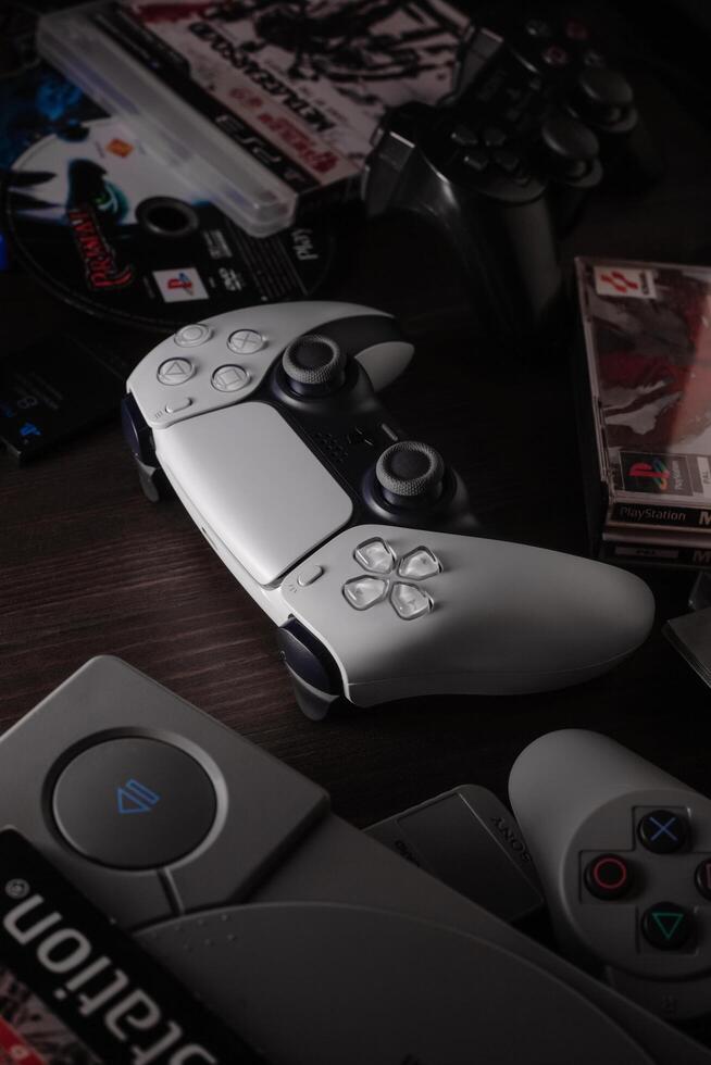 May 29, 2021, Odessa, Ukraine. White new Playstation 5 gamepad dualsense on a dark back among games and consoles of past generations. Cybersport poster concept. photo