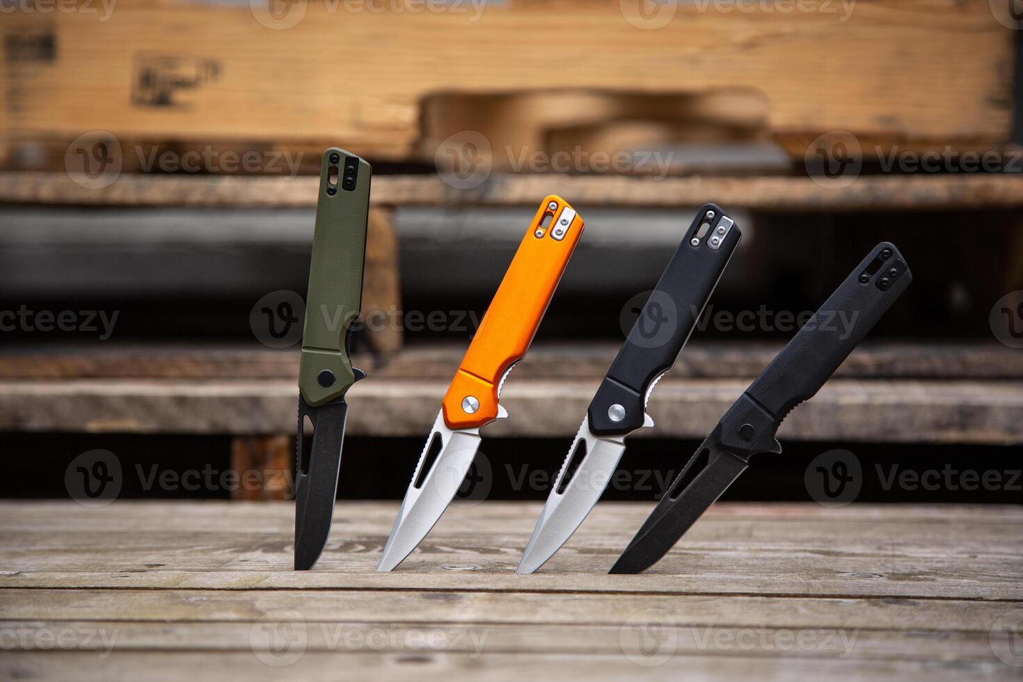 Folding penknives in different colors. Pocket knives for everyday carry. Various knives for hunting, sports and recreation. Wooden back. photo